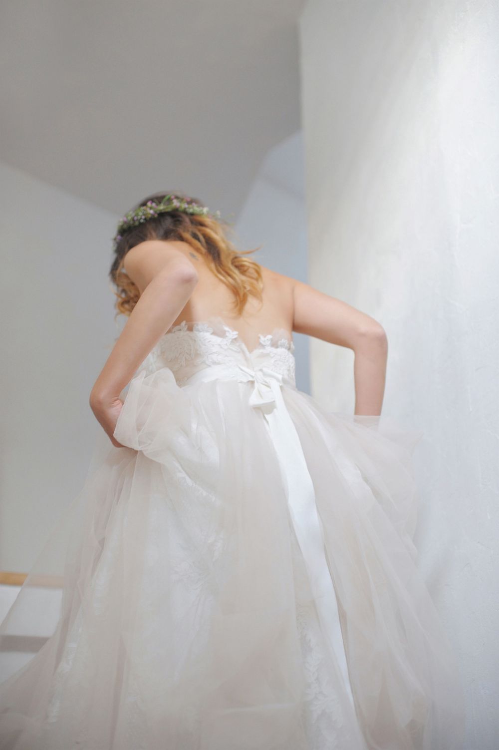 A bride in a white flowing gown and floral crown twirls to show off her dress at God's Mountain, Penticton B.C.