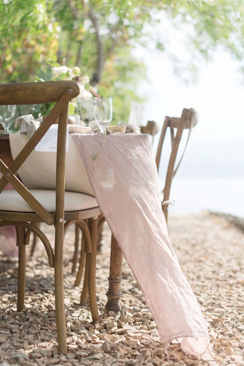 Rustic wedding table setting with wooden chairs and flowing blush fabric at God's Mountain, Penticton B.C.