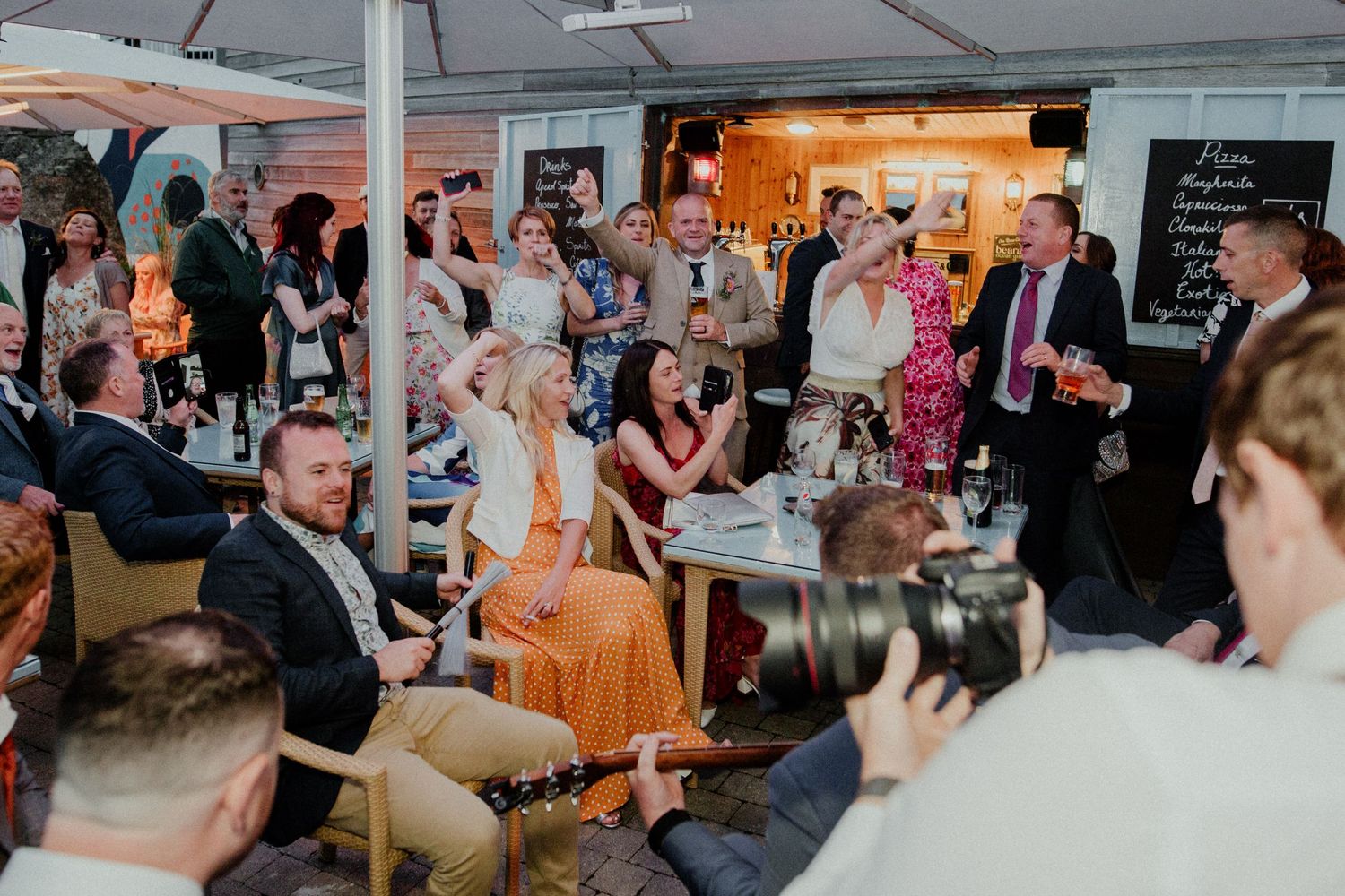 Wedding reception venue filled with guests enjoying entertainment and festivities.