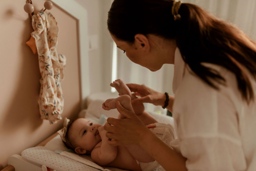 Intimate indoor portrait session showing loving interactions with a baby in natural lighting.