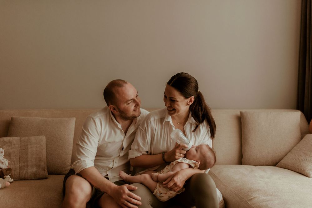 Family sharing a tender moment together while seated on beige couch.