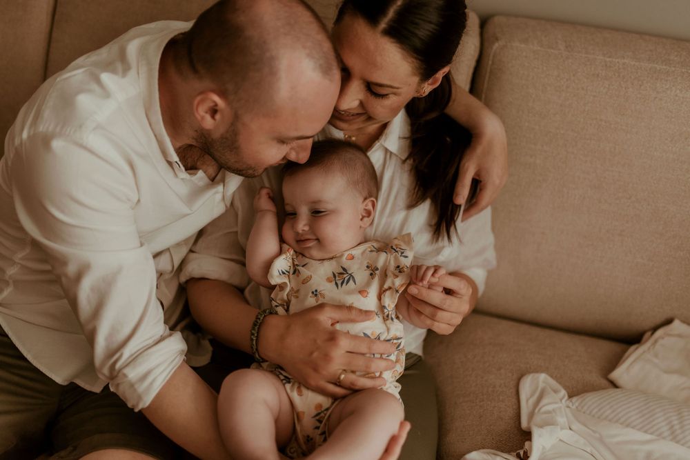 Loving family shares intimate moment together on brown sofa.