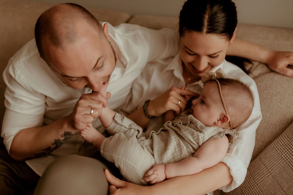 Sweet candid moment of family bonding on beige couch.
