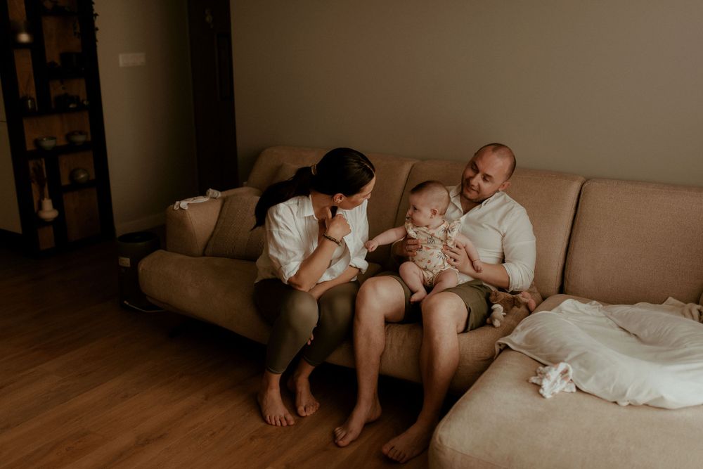 Artistic series of intimate family moments photographed on a couch in sepia tones.