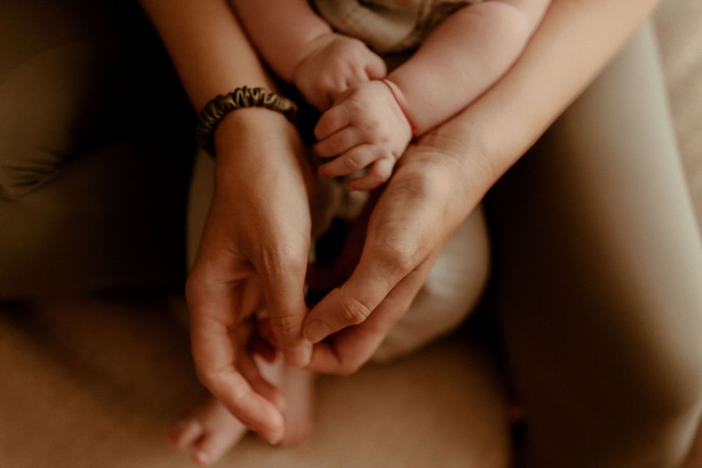Detail shot of gentle hands and tender touches during family photoshoot.