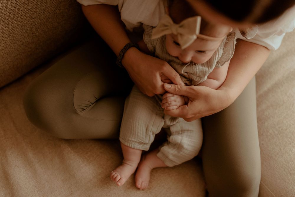 Intimate family photo session showing tender moments with a baby in warm sepia tones.