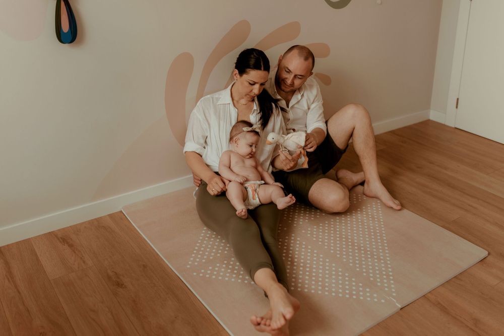 Indoor lifestyle photography session showing family interactions on floor.