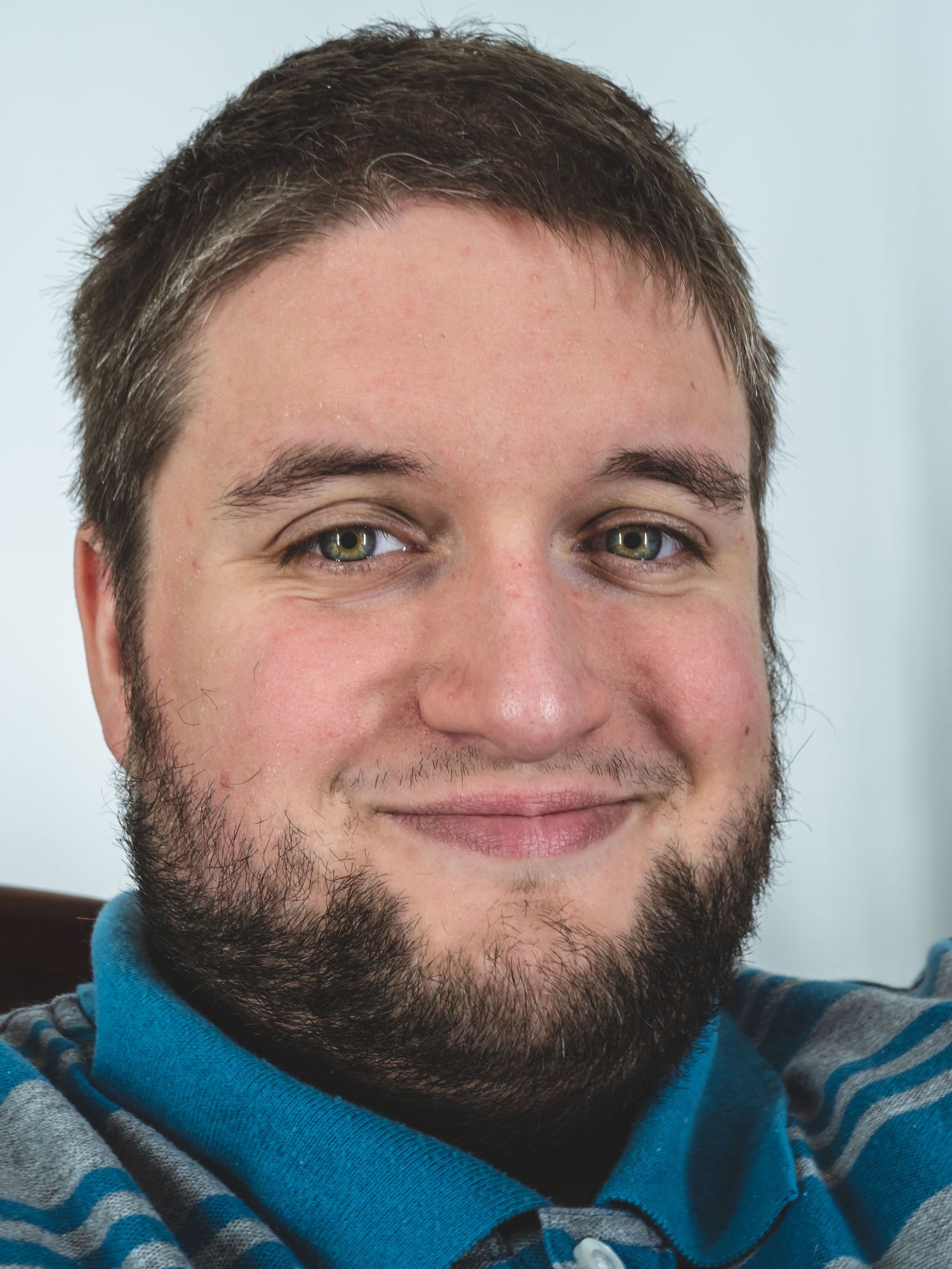 Portrait of person wearing blue sweater against light background.