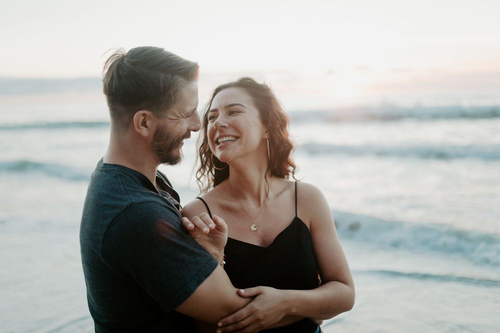 Romantic couple sharing an intimate moment on the beach at sunset.