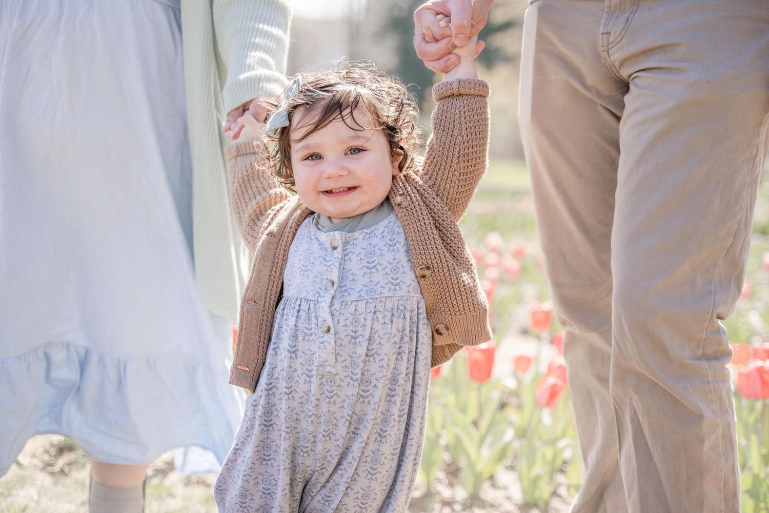 Baby Holding mom and dads hand and walking during family portraits