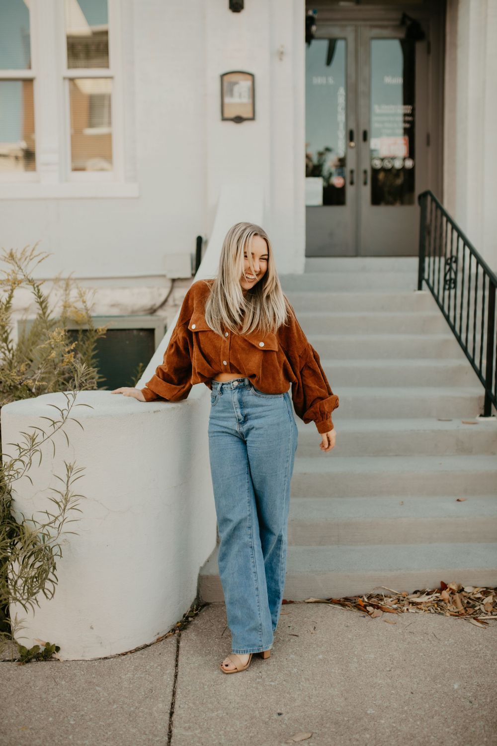Casual street style photo showcasing retro-inspired outfit with brown corduroy and wide-leg denim.