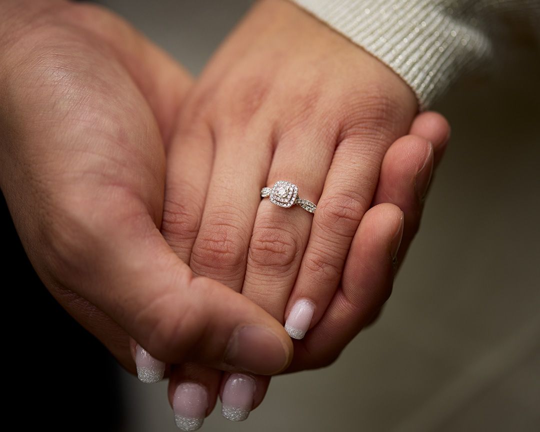 Close-up of hands holding an engagement ring