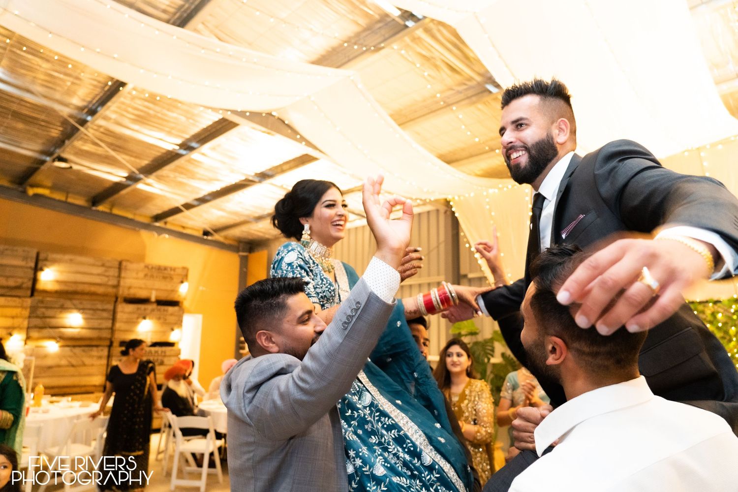 Joyous celebration moment captured at an indoor reception with people high-fiving and dancing together.