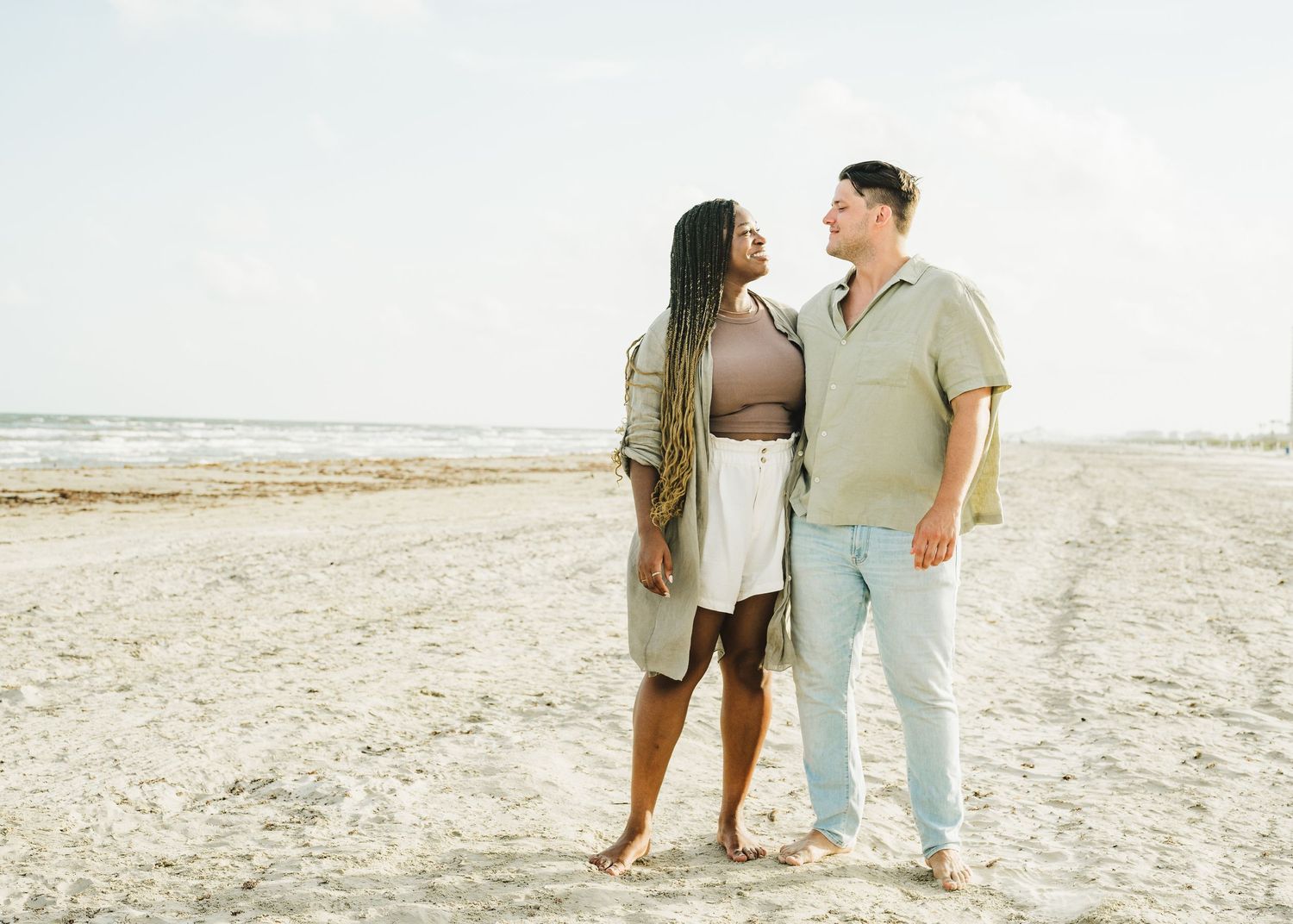 Couple enjoying romantic moment together on empty sandy beach.