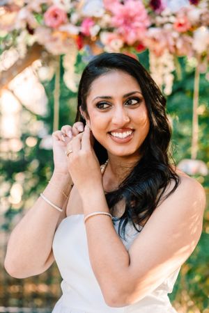 Outdoor portrait session among pink flowering trees in spring.