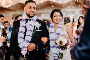 Kerala kna Catholic newlyweds in purple flower garlands during wedding reception celebration