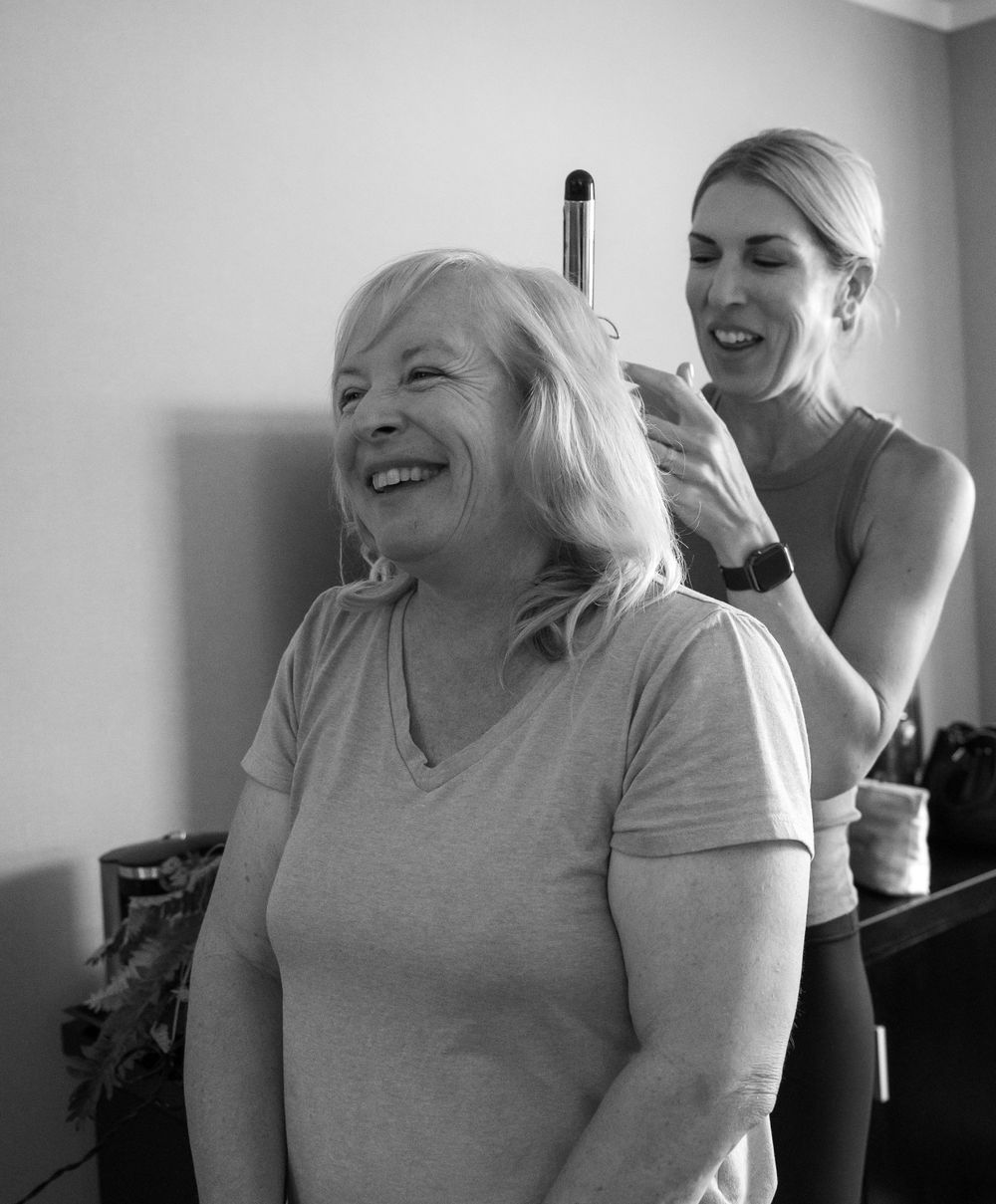 Black and white photo of hair styling preparation during wedding day preparations.