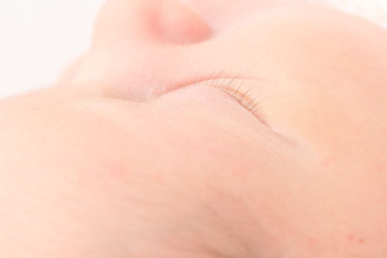 close up of a four day old newborn baby boy of his eyelashes in a detail photo all white theme studio