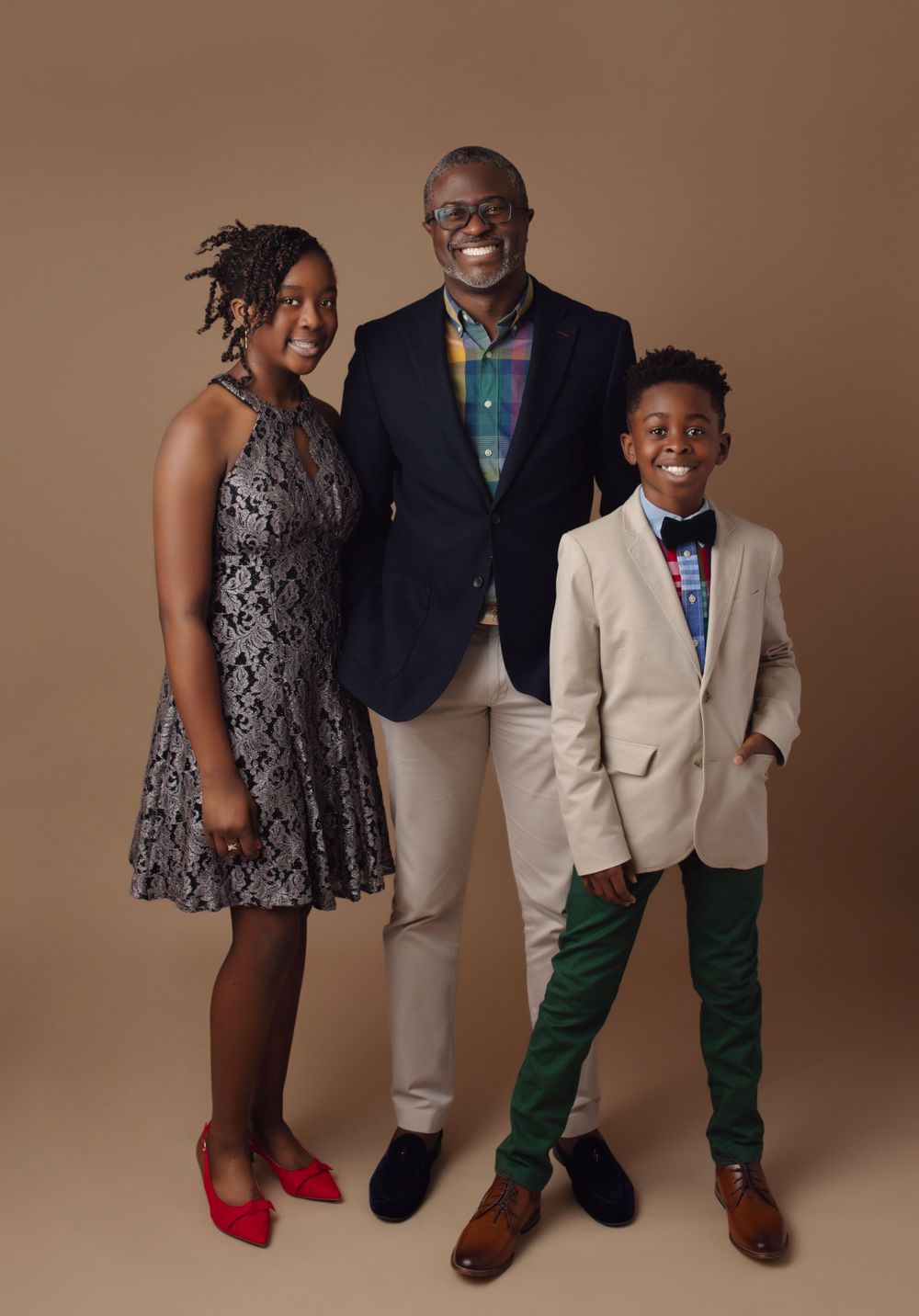 Stylish family portrait series against brown backdrop featuring coordinated formal outfits and elegant poses.