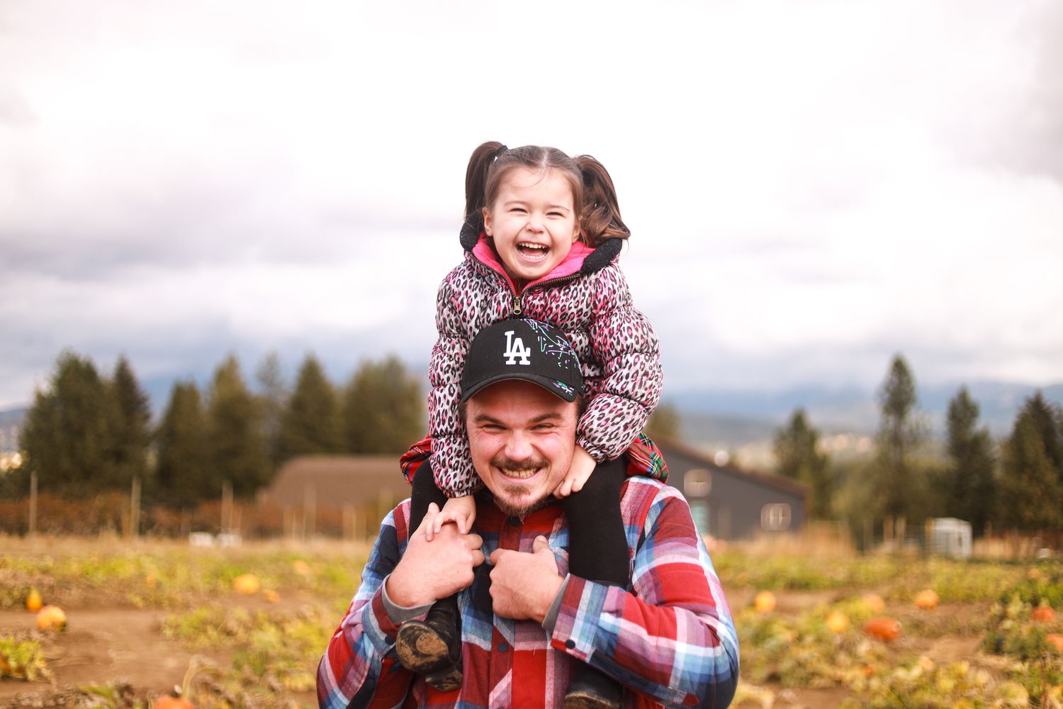 A joyful piggyback ride moment captured in a scenic autumn field.