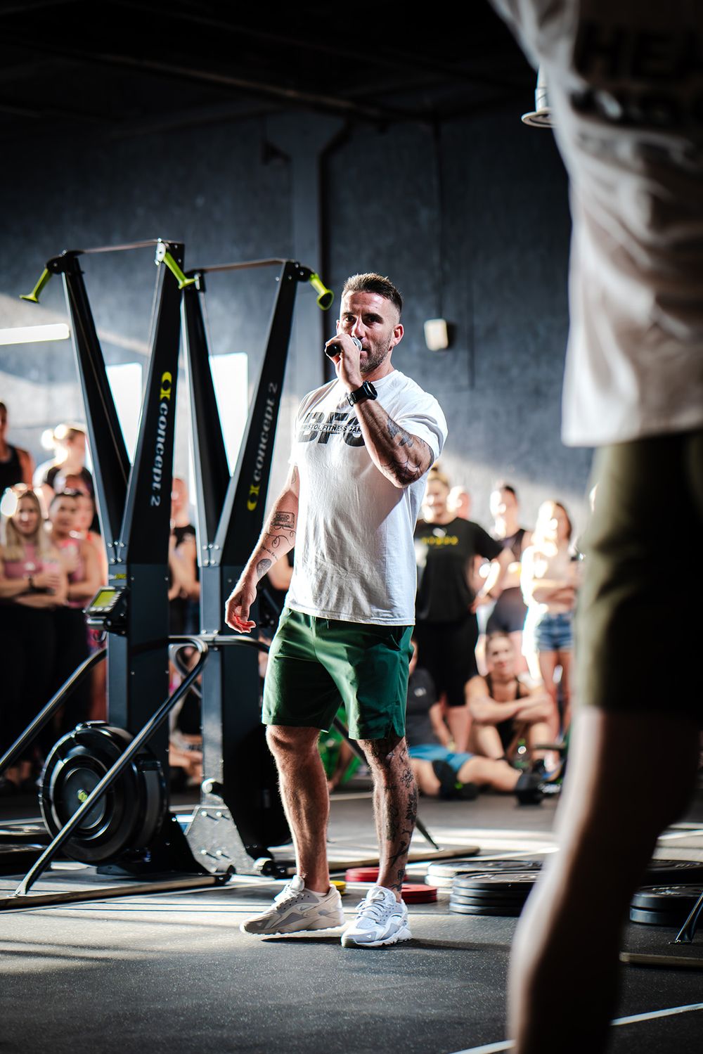 Fitness instructor leading a workout class in an industrial gym setting.