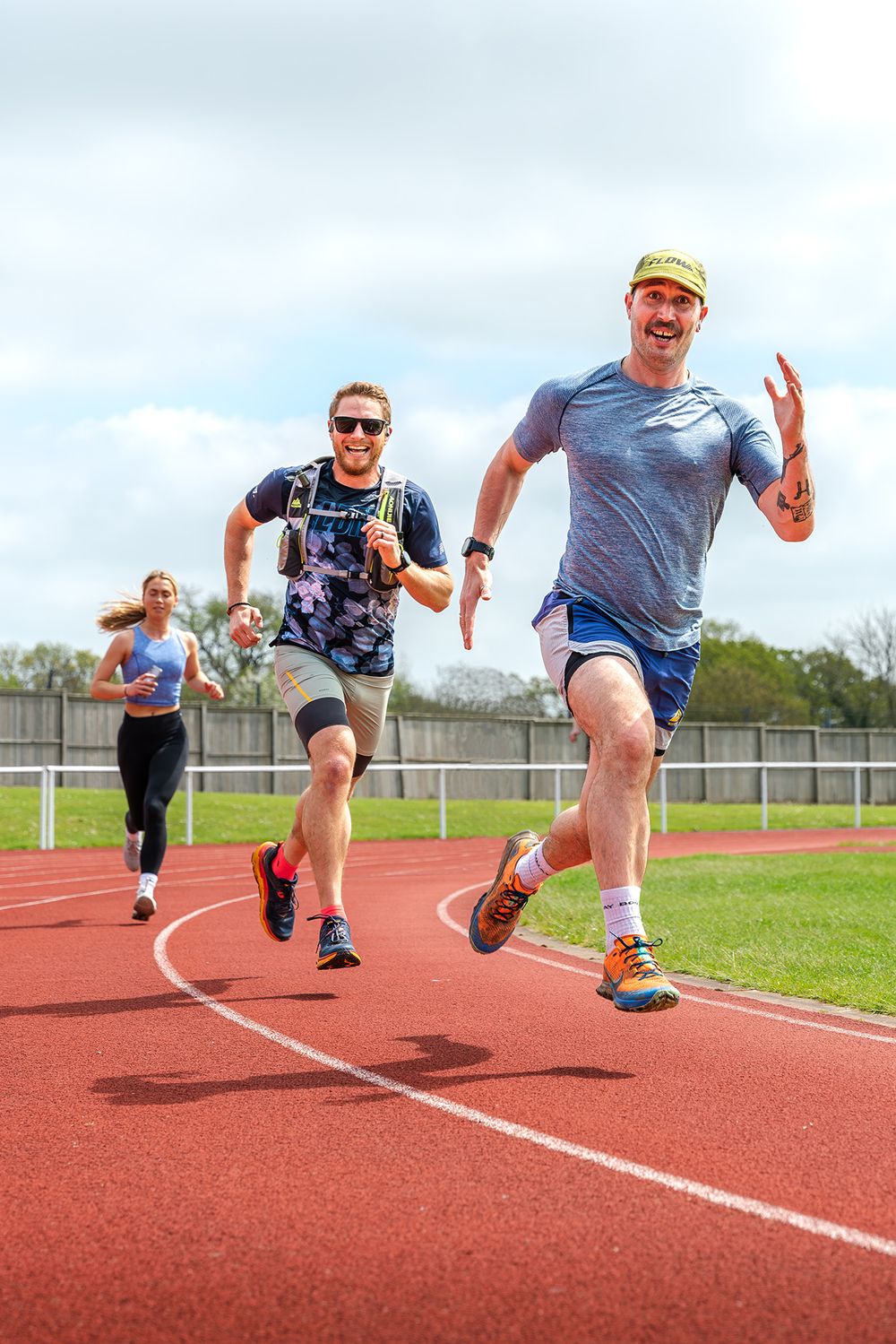 Athletes racing on an outdoor running track during competition.