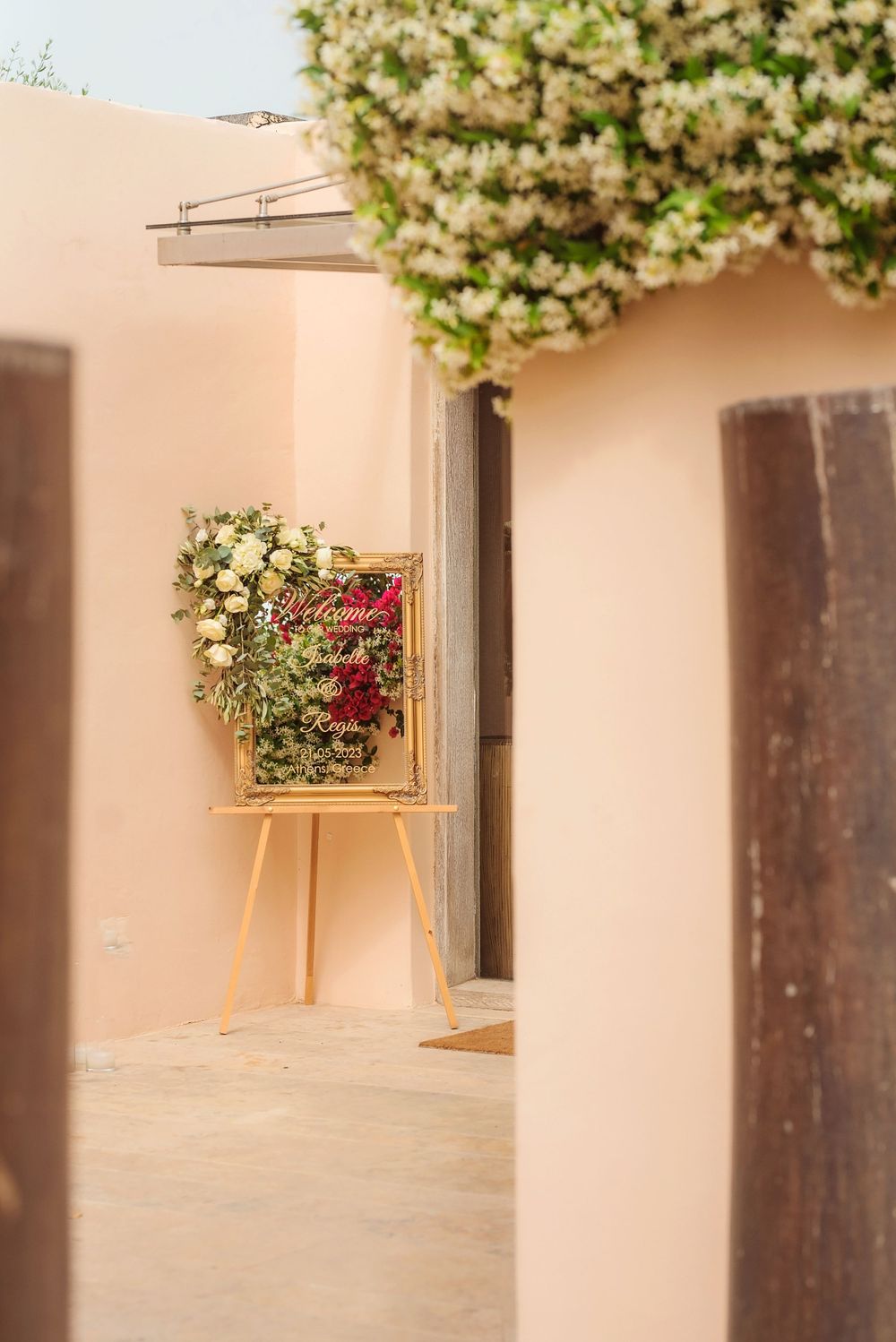 An elegant floral display on an easel against a peach-colored wall.