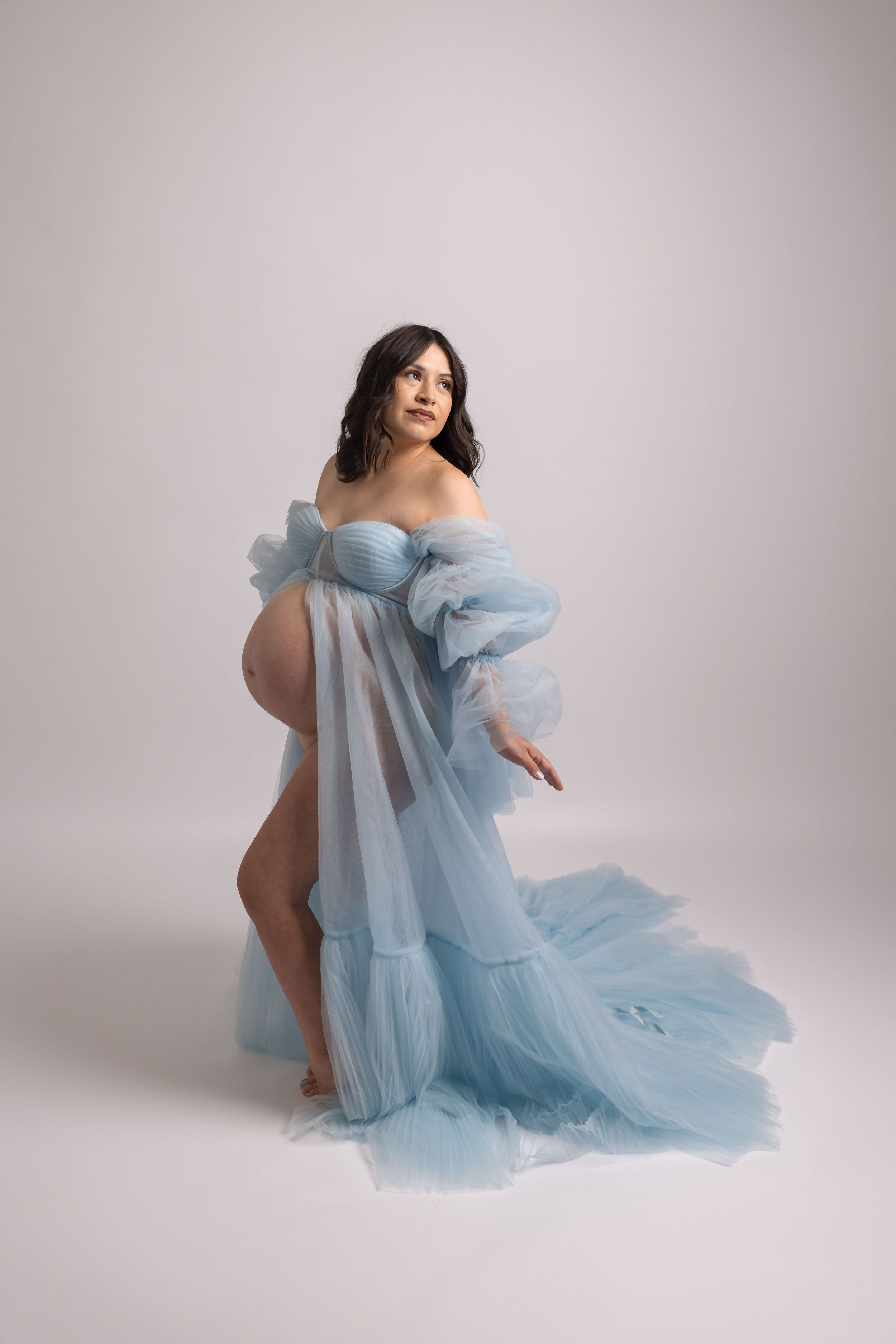 Romantic maternity portrait in flowing light blue tulle gown.