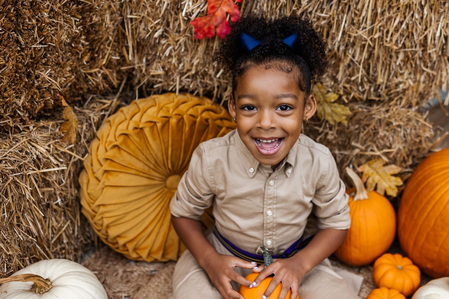 Festive fall photography setup with pumpkins and hay bales.