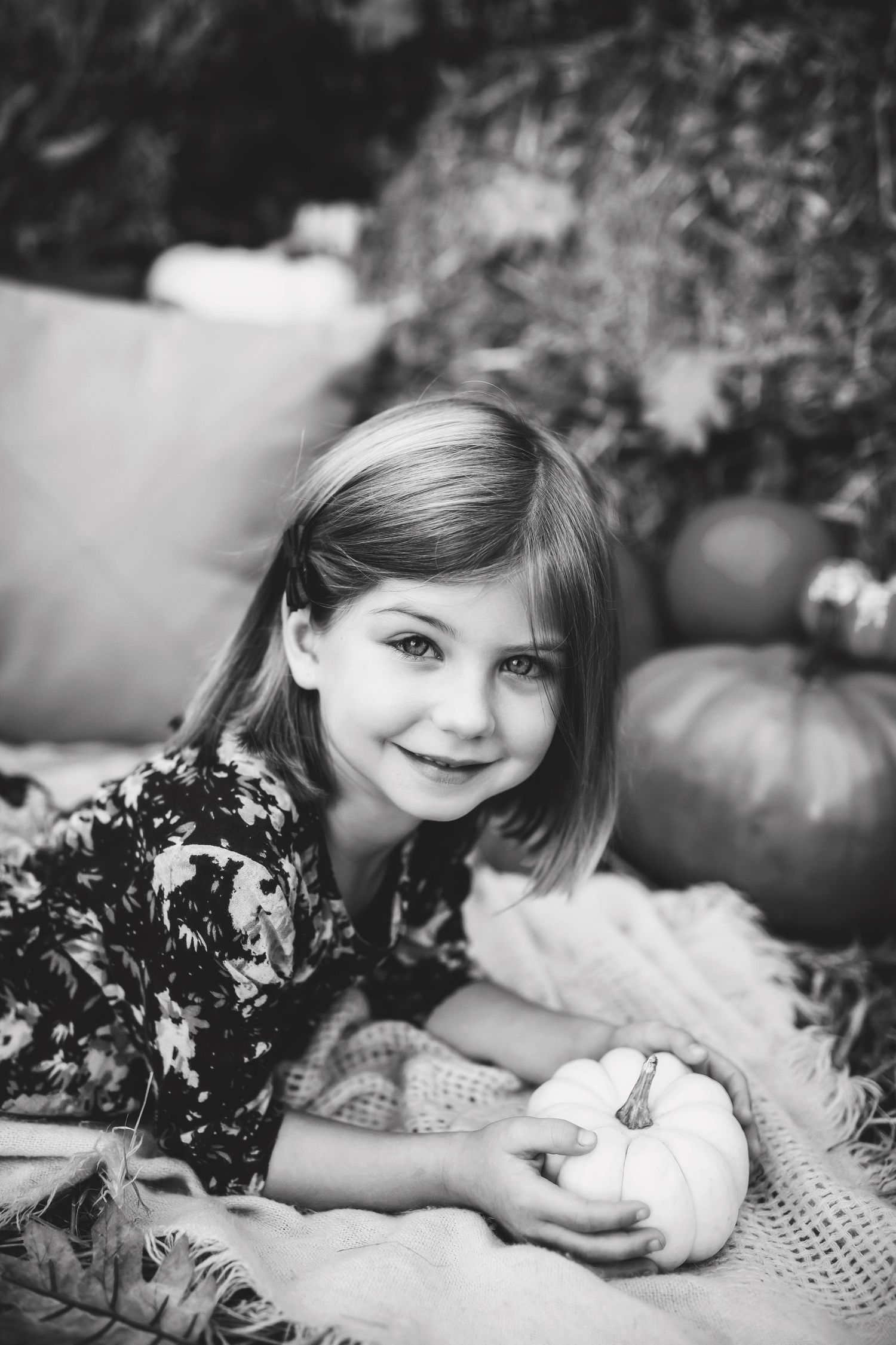 Black and white autumn portrait with white pumpkins and floral patterns.