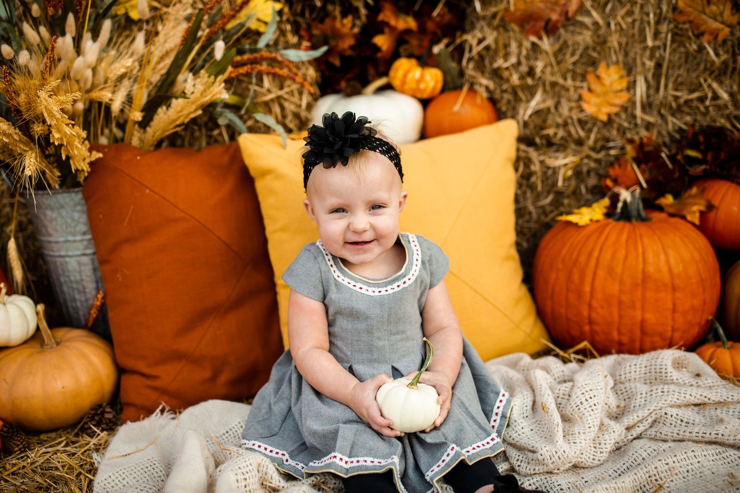Fall-themed portrait session with pumpkins and rustic decorative elements.