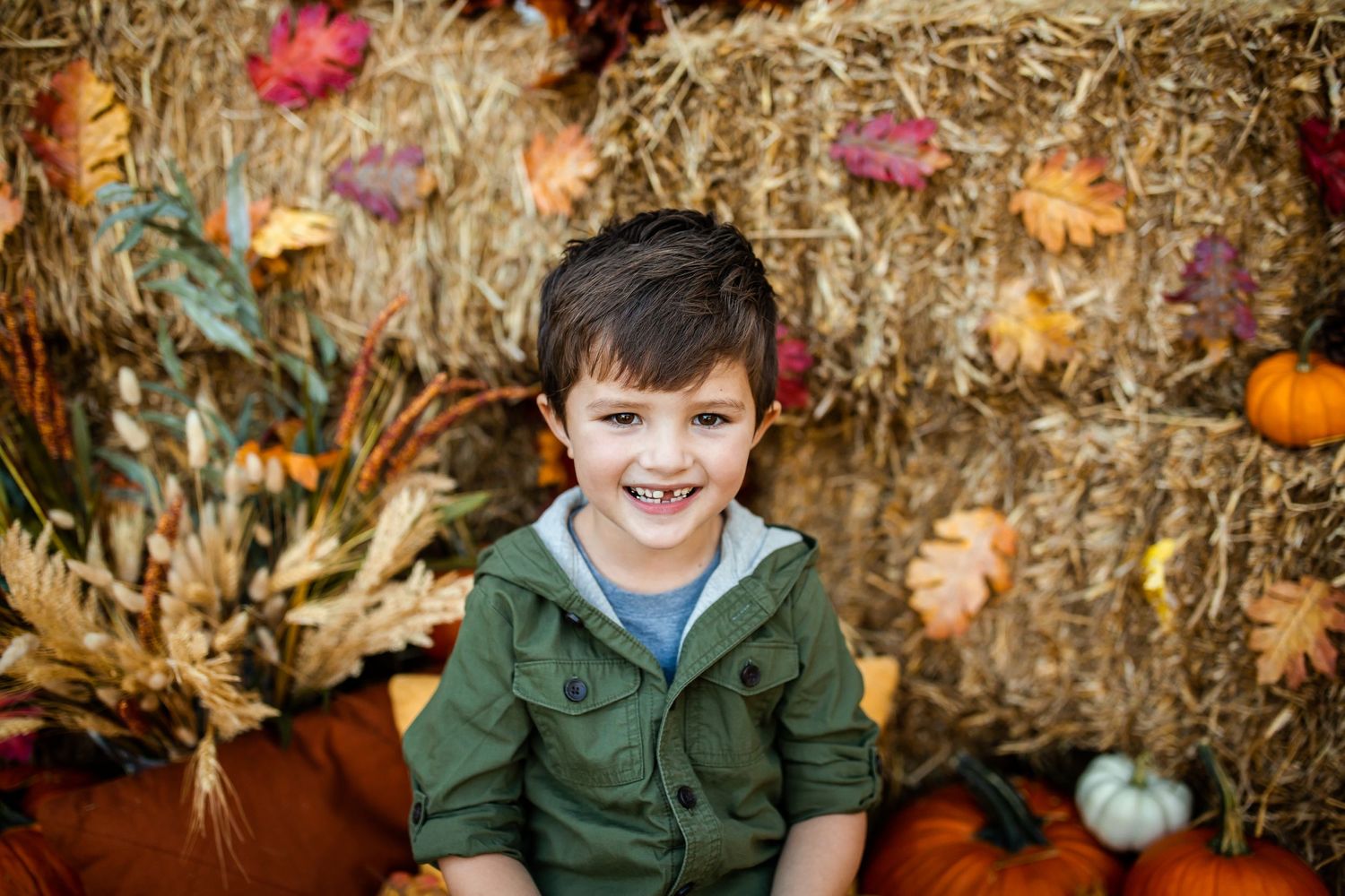 Autumn portrait session with hay bales, pumpkins and fall foliage.