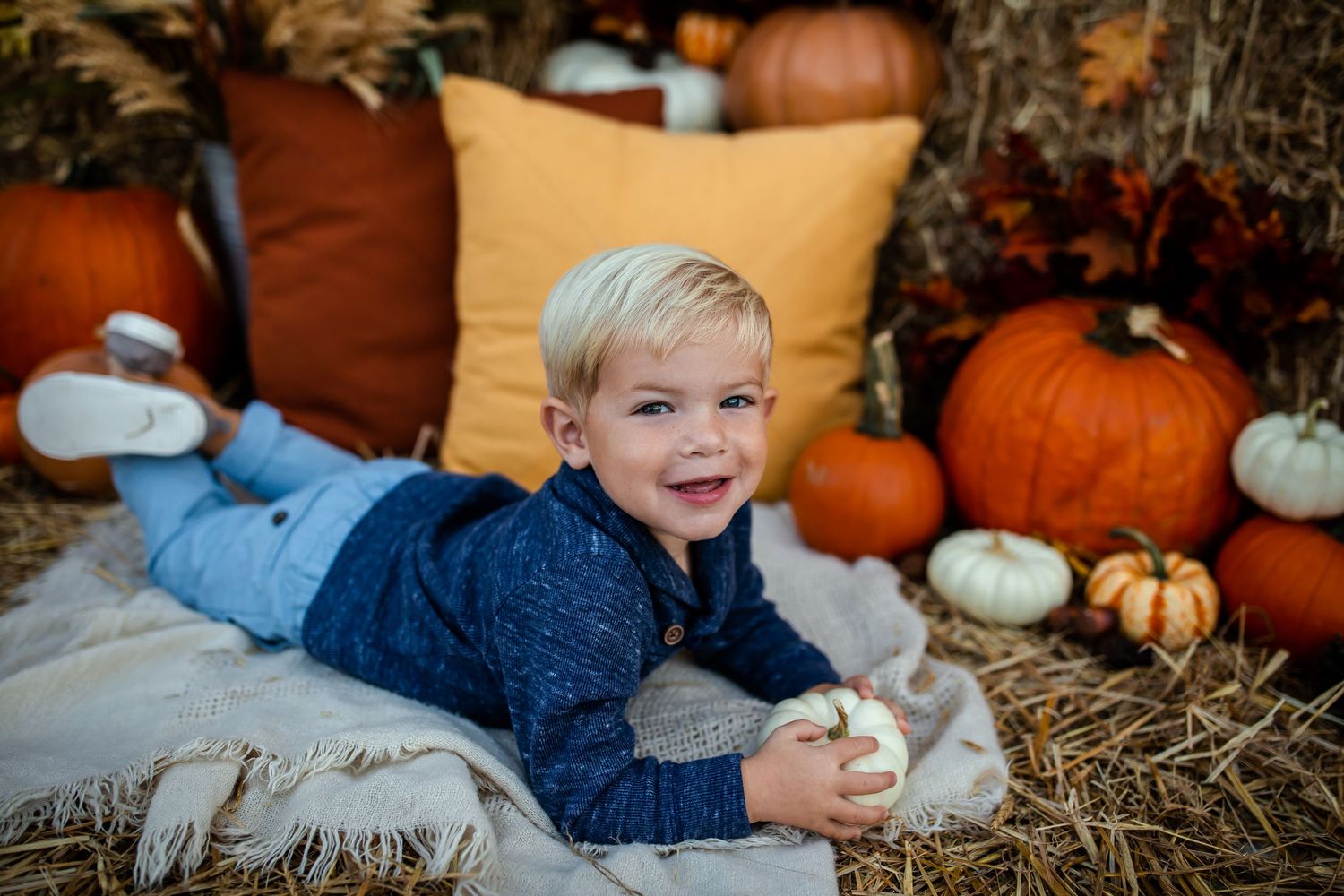 Rustic fall scene with decorative pumpkins and cozy autumn decor on hay bales.