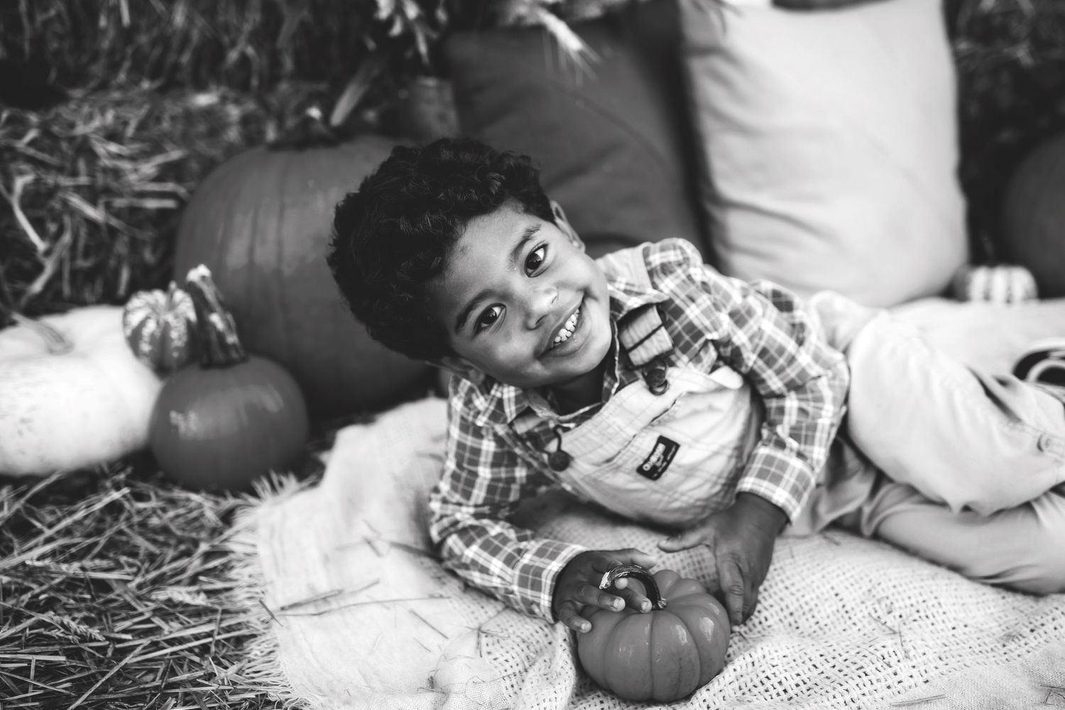 Black and white portraits on blanket with autumn decorations.