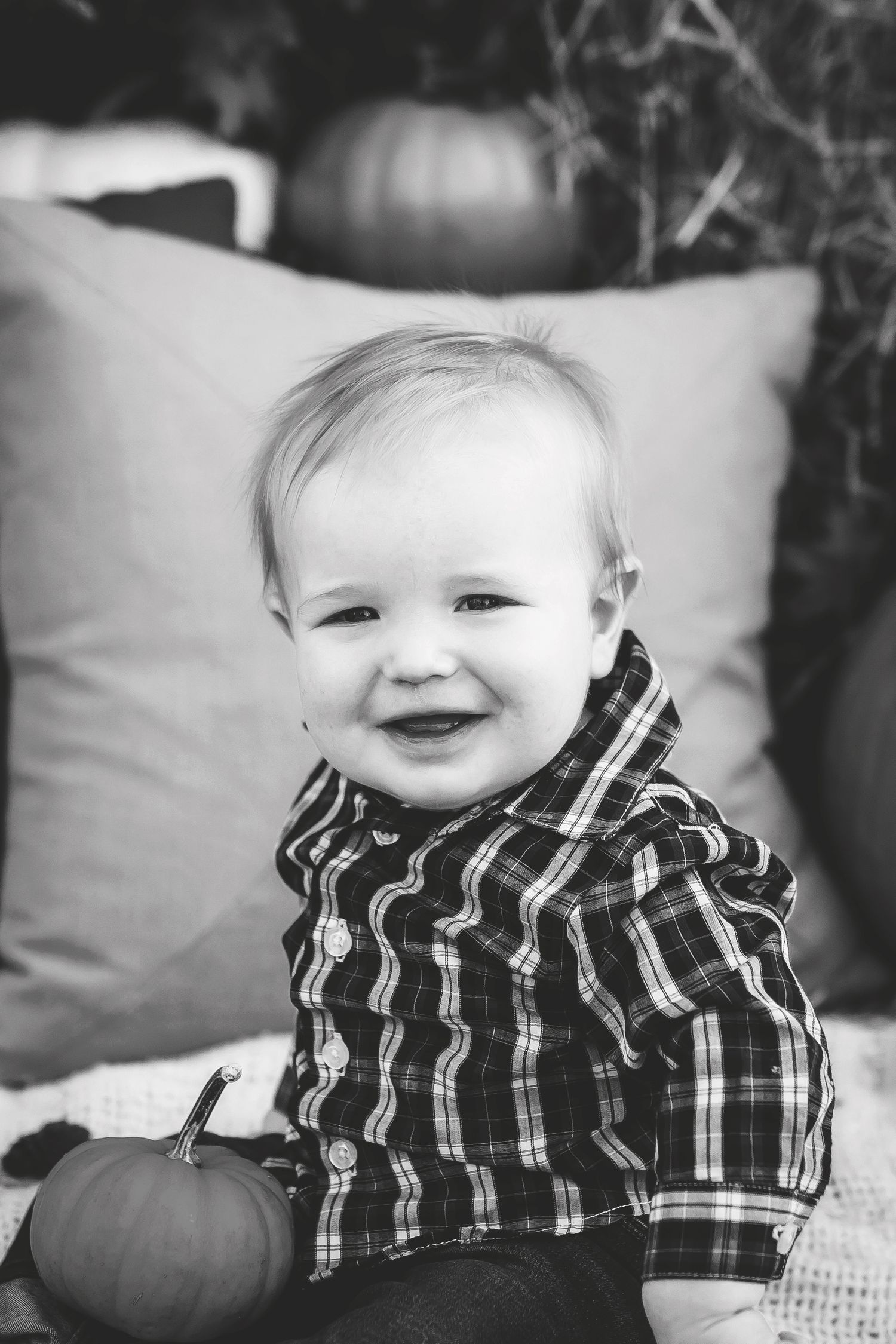 Black and white portrait showing joyful expressions against soft pillows.