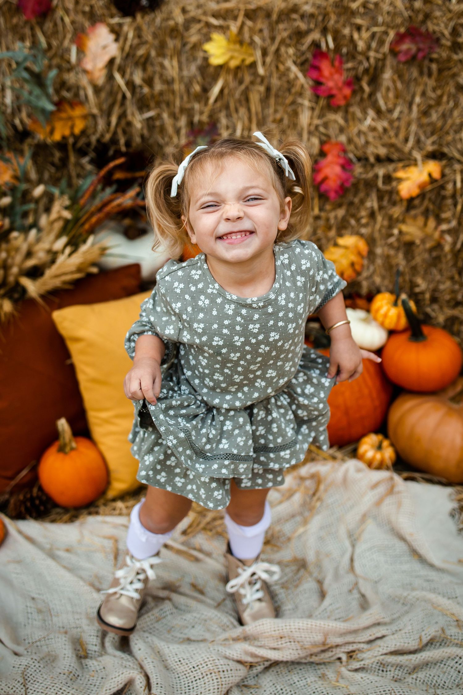 A polka dot dress creates a playful autumn scene with orange pumpkins and fall leaves.