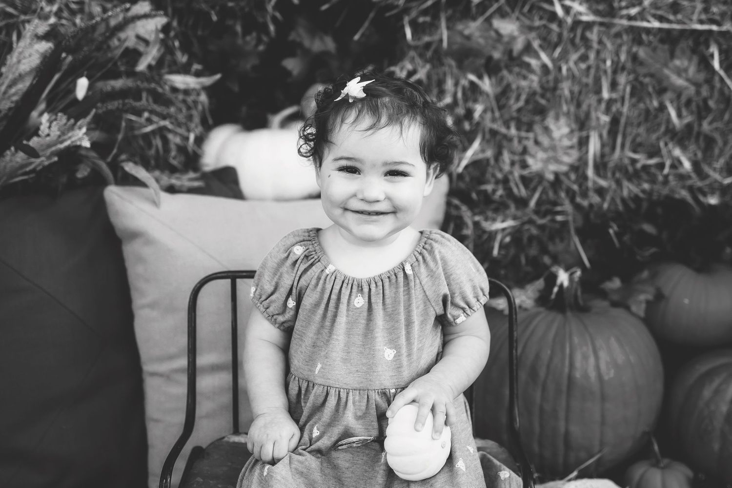 Happy expressions captured against a backdrop of autumn decor and pumpkins.