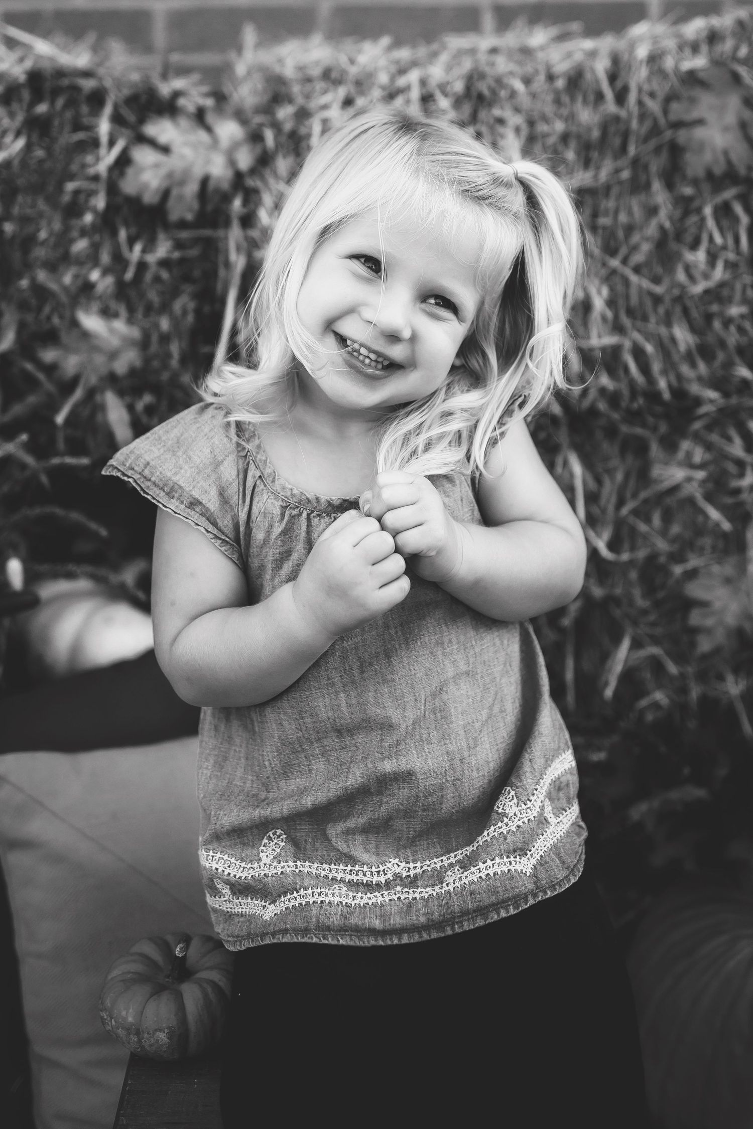 Black and white portrait showing pure joy against a rustic outdoor background.