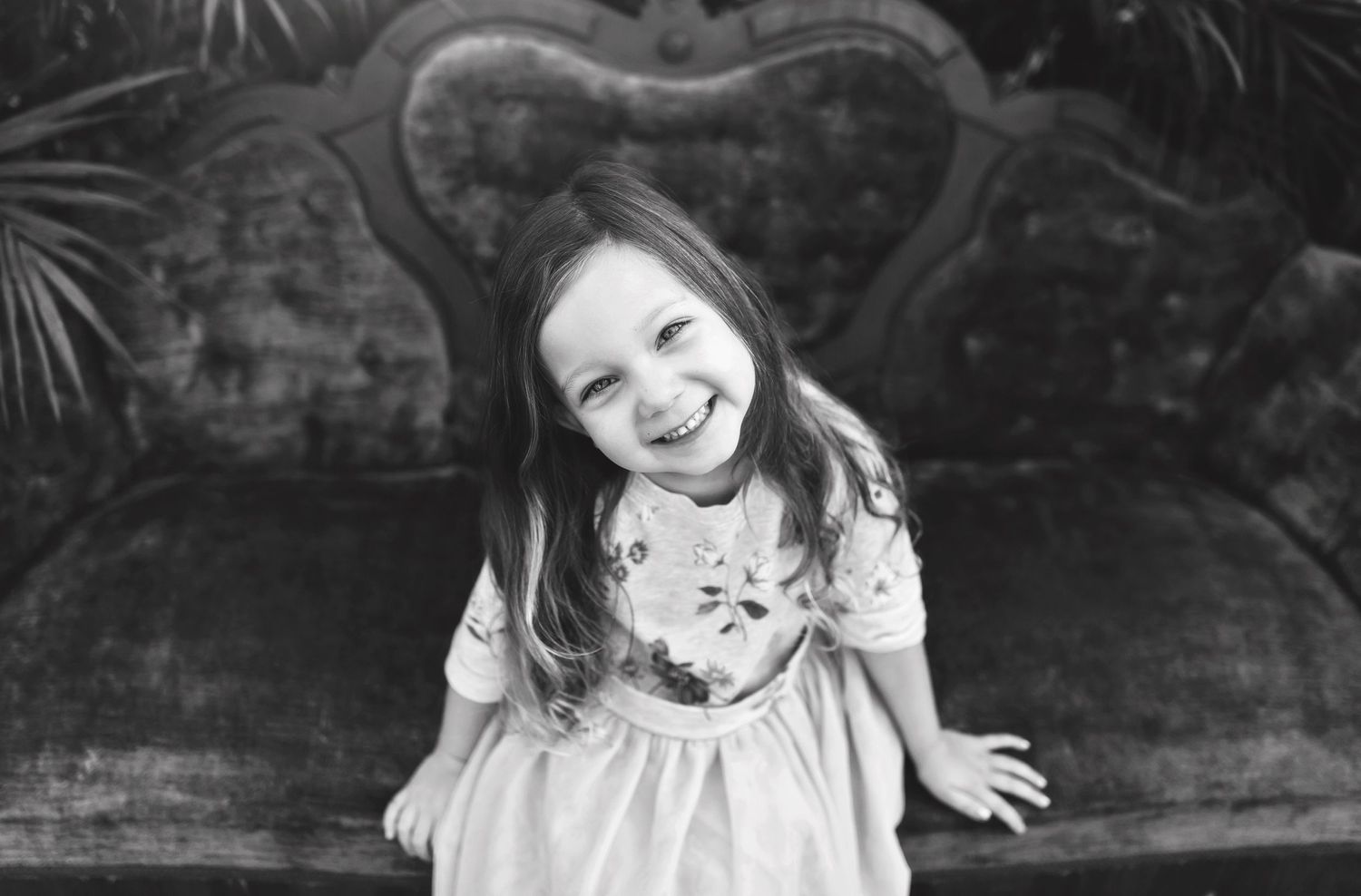 Black and white portrait session featuring relaxed poses on an antique sofa.