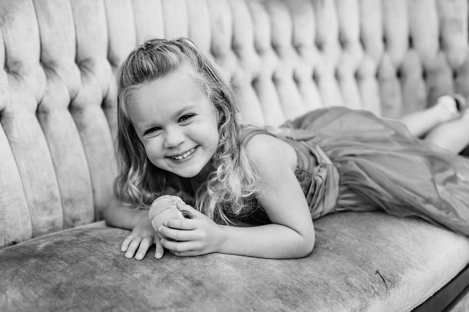 Artistic black and white captures of joyful moments on a plush vintage sofa.