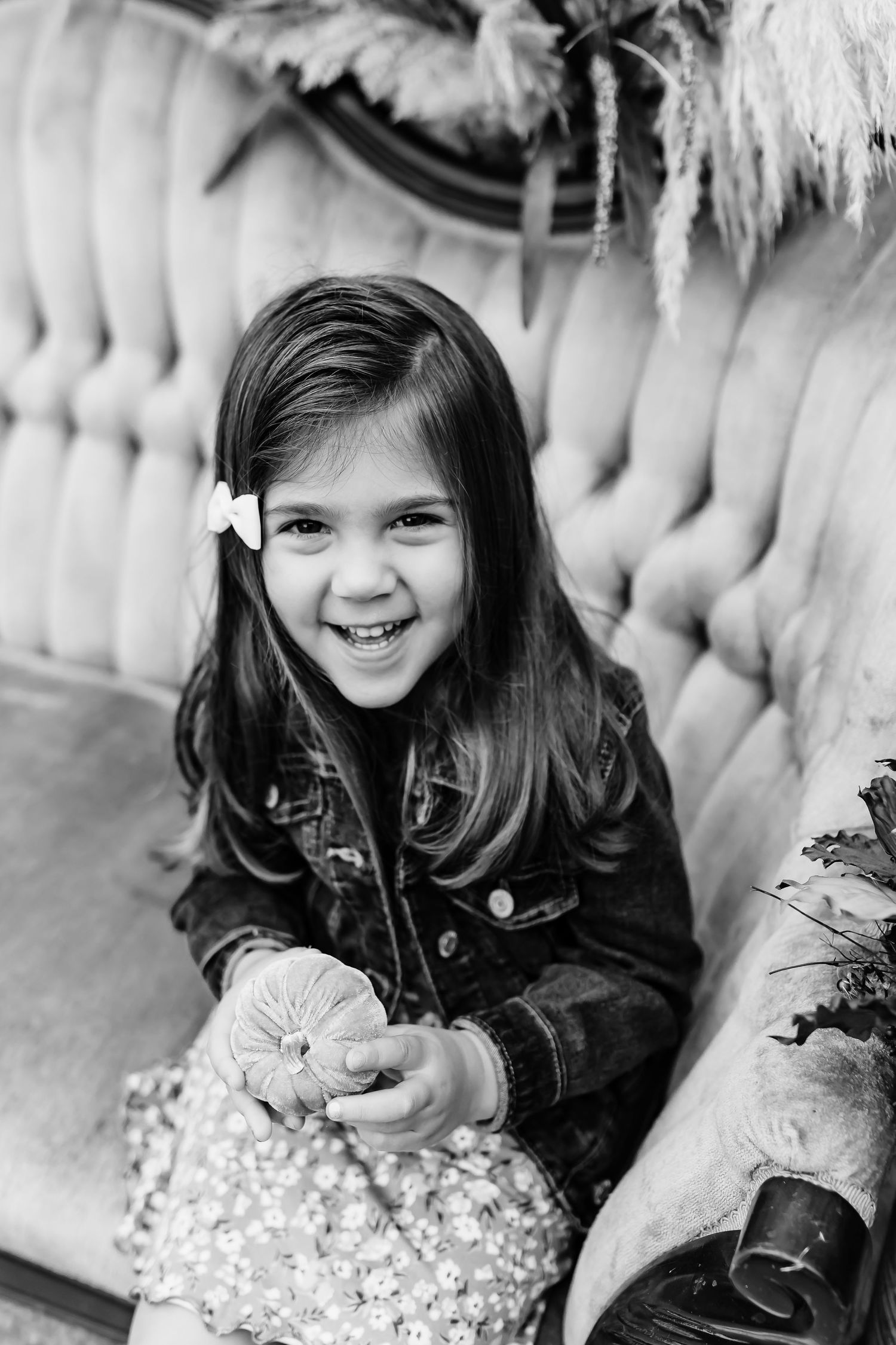 Black and white portraits showing natural expressions against a tufted backdrop.