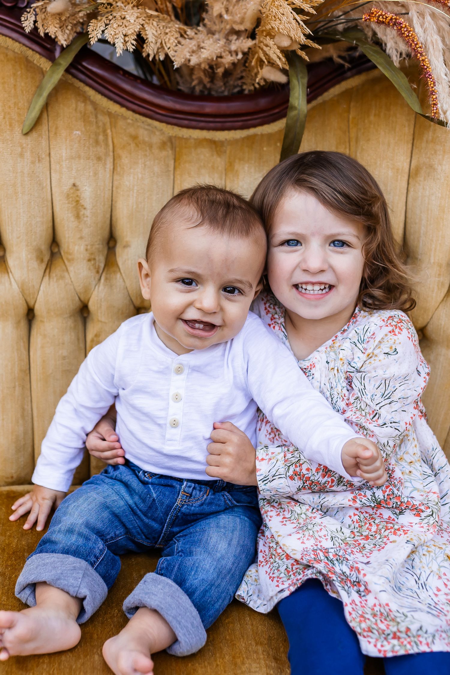 Children in coordinated spring outfits share playful moments on a gold tufted sofa.