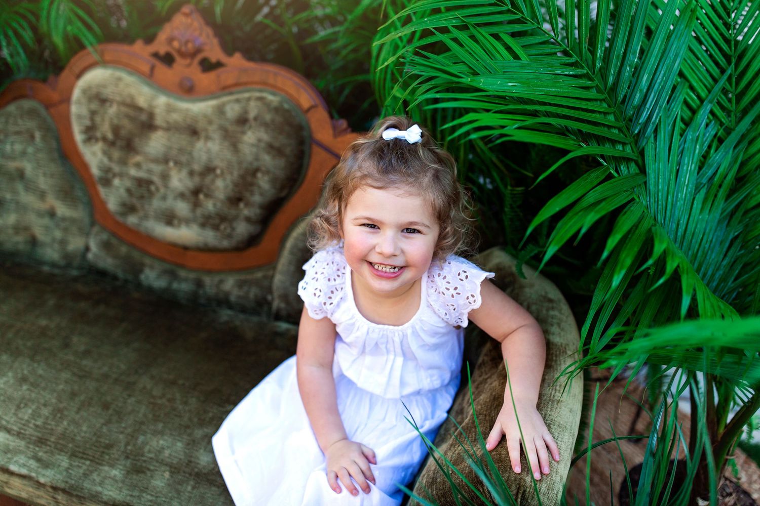 Garden photoshoot featuring white dresses and tropical green foliage.