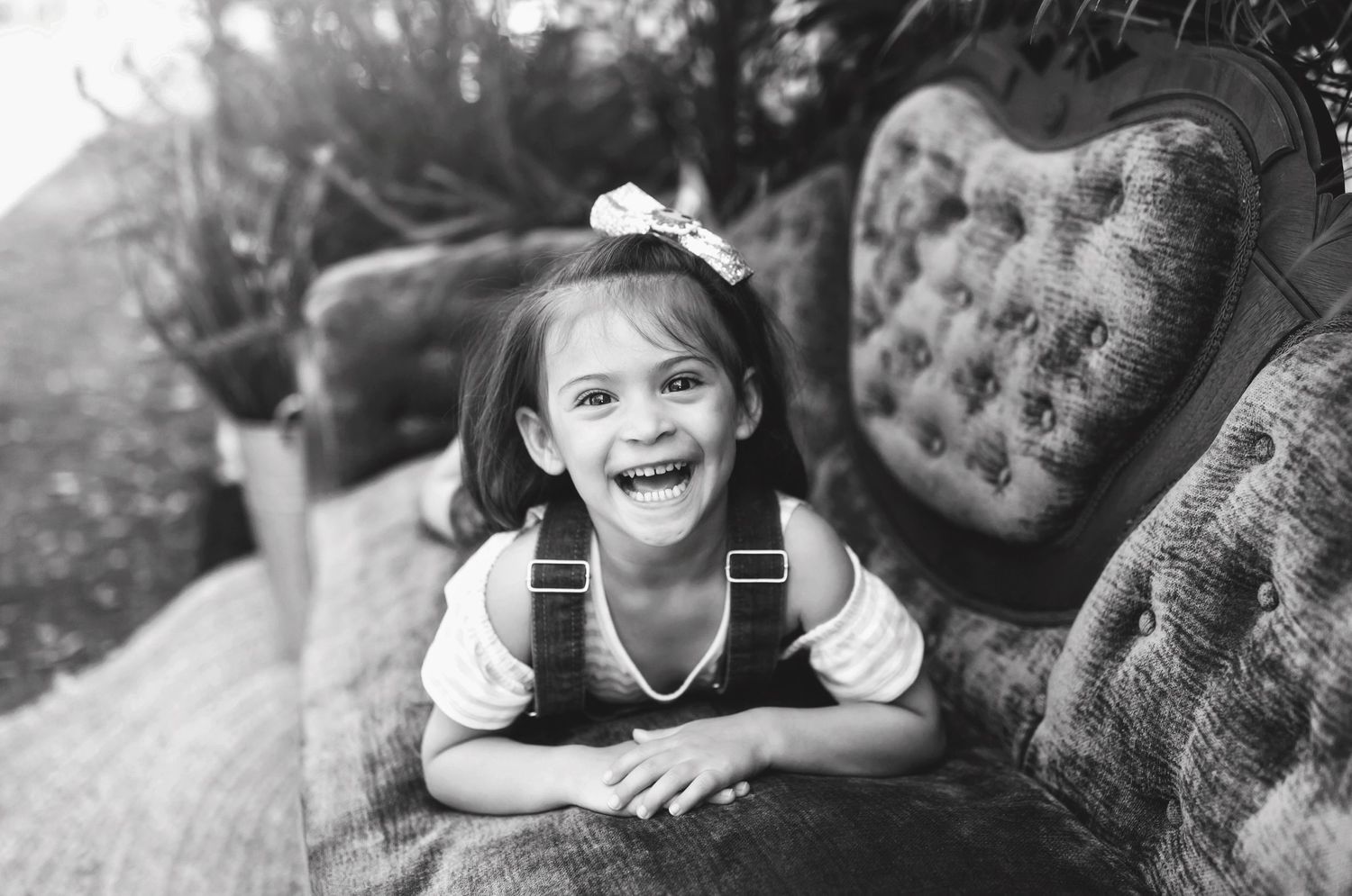 Black and white series of joyful expressions on a vintage couch.