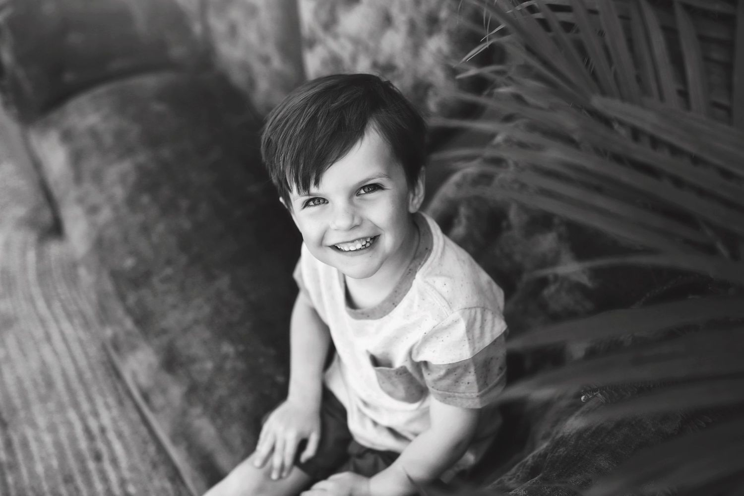 Black and white portraits of children playing and laughing during an outdoor photo session.