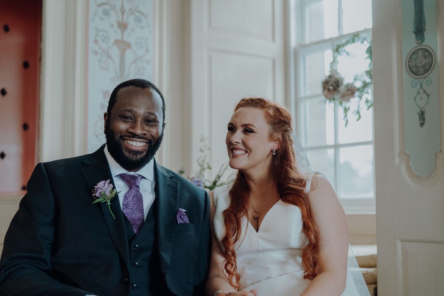 A joyful wedding couple sharing a moment together in an elegant room.