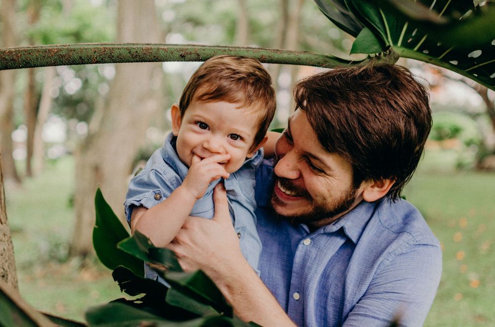 A playful moment shared among leaves and branches in a sunny garden setting.