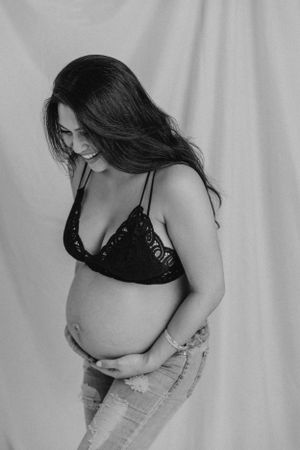 Black and white maternity portrait with denim and lace details.