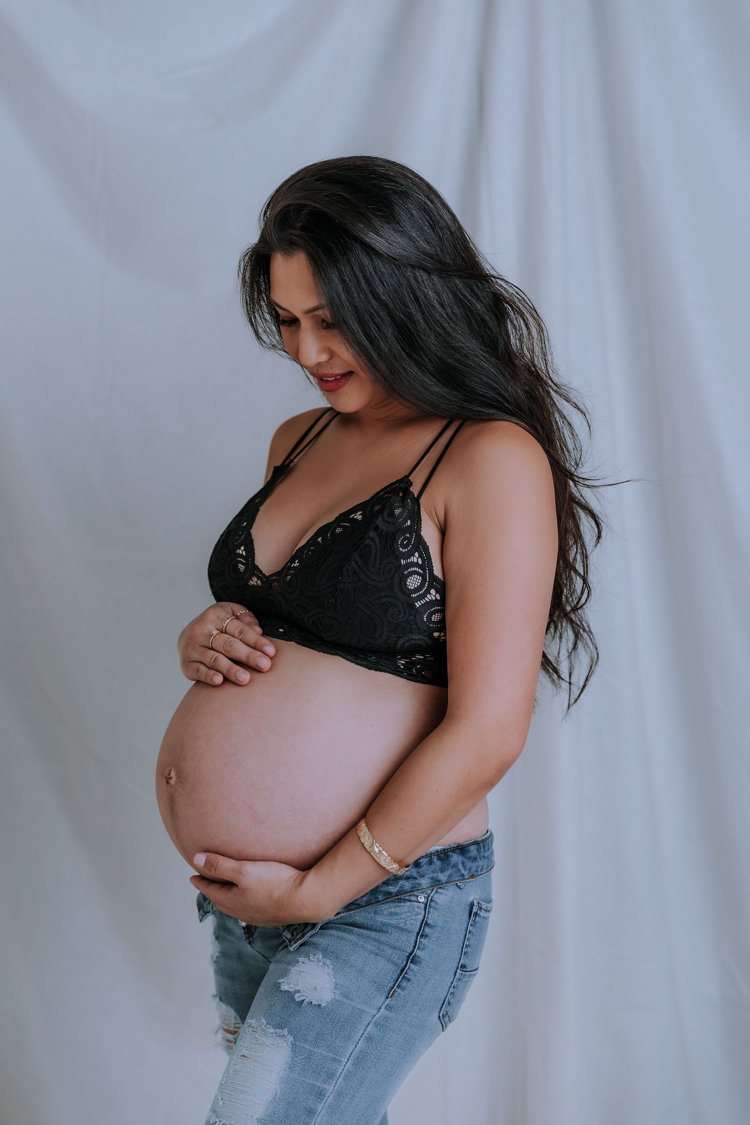 Artistic maternity photos showing pregnancy silhouette in black lingerie.