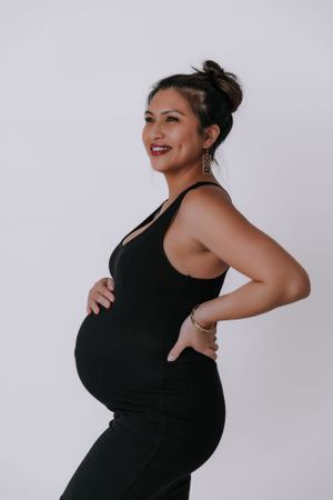 Maternity photos in black dress showing side profile poses.